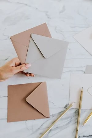 photo d'une main qui tient 2 enveloppes